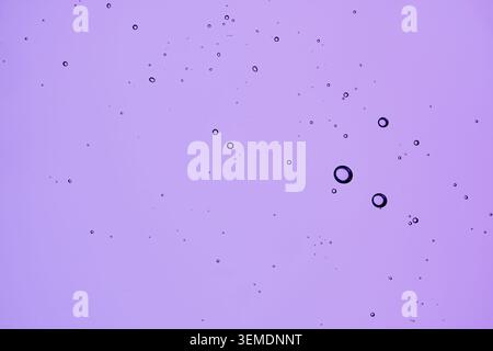Texture of cosmetic serum with bubbles on purple background Stock Photo