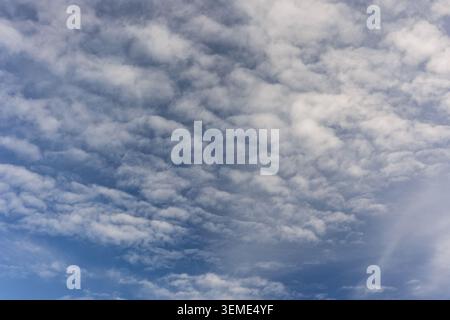 Thick cloud formations with visible blue openings creating contrast in a changing sky Stock Photo