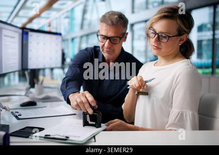 Two Business Managers Reviewing Documents For Final Contract Signoff Today. Stock Photo
