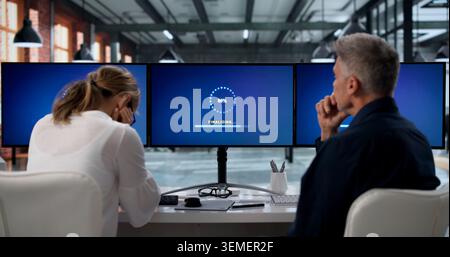 Two IT Specialists Working Together To Update Slow Computer Systems. Stock Photo