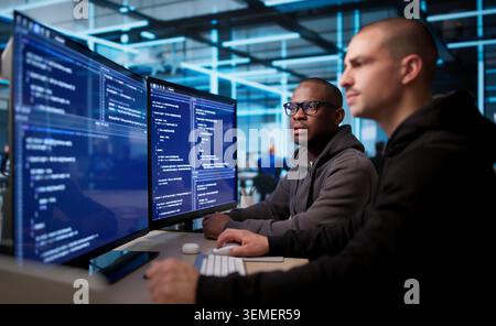 Two Software Engineers Working Together On Secure Business Application Code. Stock Photo