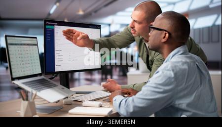 Procurement Manager And Colleague Analyze Software Platform To Improve Purchasing Decisions. Stock Photo