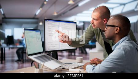 Software Engineers Work Together In Office Coding Secure Web Systems. Stock Photo