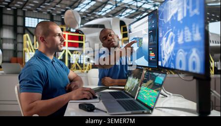 Two Aircraft Technicians In Uniform Working Together On Jet Engine Repair. Stock Photo