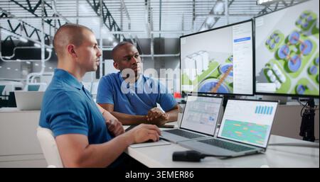 Two Engineers Using Computers To Monitor Water Treatment Plant Systems. Stock Photo