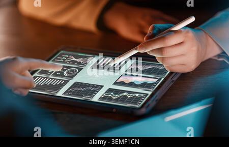 Modern business professionals collaborate using a digital tablet displaying interactive financial charts and analytics. The hands-on teamwork and adva Stock Photo