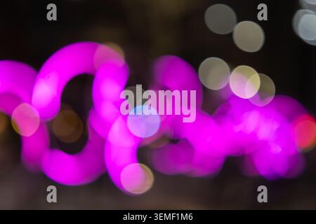 Abstract blurred pink neon lights in the city at night Stock Photo