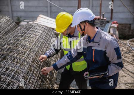 Asian engineer inspecting steel wire mesh on construction site, Construction workers study wire mesh at site, Civil Engineer exam specification of raw Stock Photo
