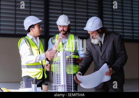 Engineers stand in thought while real estate developer plans and meeting construction project in collaboration with engineers and reviews blueprints a Stock Photo