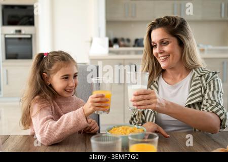 Happy Mother and Daughter Having Healthy Breakfast Together at Home Stock Photo