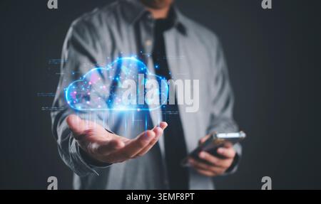 Businessman holding smartphone with virtual cloud computing hologram. Global network connection, data storage security, and digital transformation con Stock Photo