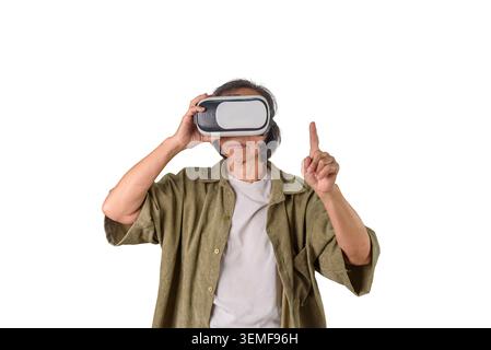 Senior Asian woman wearing VR headset pointing finger touching virtual interface screen on white background. Elderly technology lifestyle, metaverse g Stock Photo
