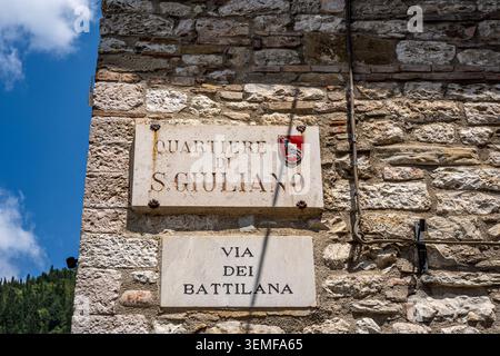 Street plaque of San Giuliano historic district, mounted along Via Battilana in medieval old town, Gubbio, Umbria, Italy Stock Photo