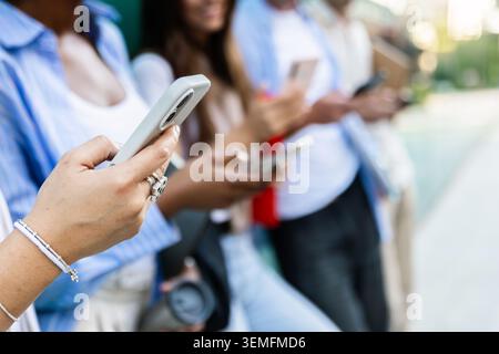 Diverse students using smart phones while spending time together Stock Photo