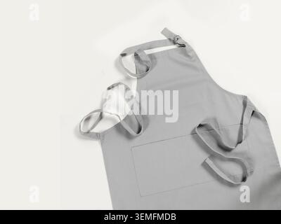 Minimalist gray cotton apron mockup with spacious front pocket and adjustable neck strap. Blank kitchen textile template for branding design Stock Photo