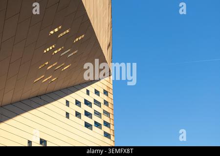 Horizontal abstract view of MECA Bordeaux, angled facade panels casting dramatic geometric triangle shadows contrasting with vivid blue sky, like a gr Stock Photo