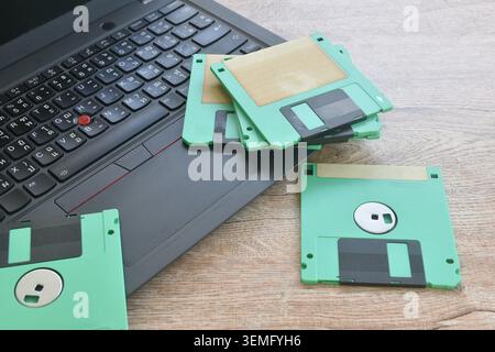 floppy disk old technology for saving data arranging with laptop computer on table Stock Photo