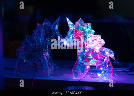 transparent unicorn lamp with led lights on kissing another unicorn lamp with light off Stock Photo