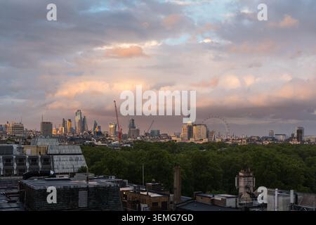 Panoramic view of the London skyline under an overcast cloudy sky with the City of London skyscrapers rising above green parkland, England, UK Stock Photo