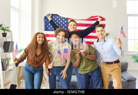 Diverse friends celebrating USA Independence Day at home with American flags. Stock Photo