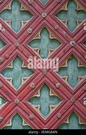 A geometric carving on an aged wooden door is viewed at a close distance. Stock Photo