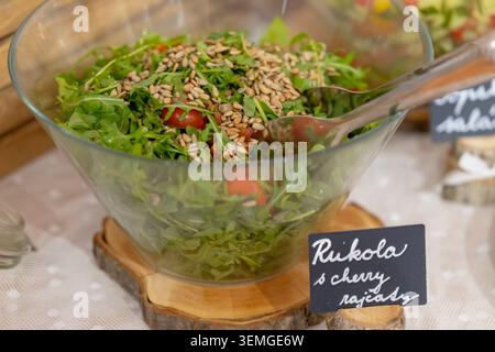 Fresh green salad with sunflower seeds and cherry tomatoes served in a glass bowl Stock Photo