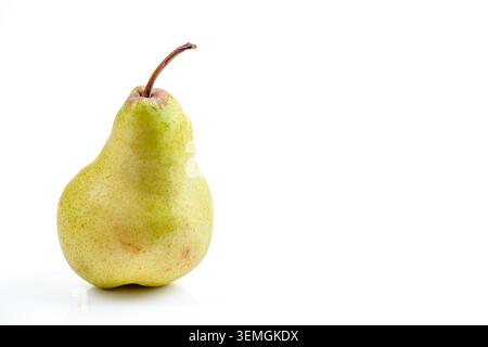 A solitary, fresh, yellow-green pear with a delicate brown stem stands against a stark white backdrop, highlighting its natural form and texture Stock Photo