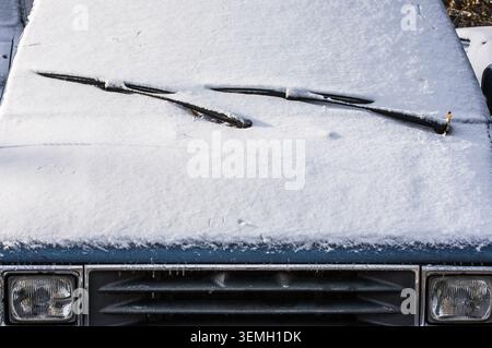 A car sits outside in Gothenburg, Sweden, completely covered in snow. The windshield wipers rest on top, unable to clear the thick white blanket. Wint Stock Photo
