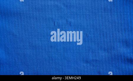 Flat lay texture of vibrant blue ribbed jersey knit fabric showing fine vertical lines Stock Photo
