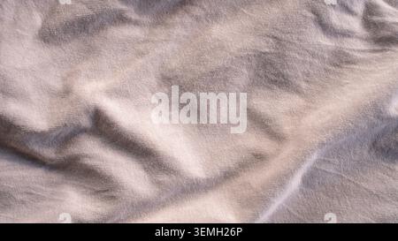 Soft gray fabric texture background with subtle creases and gentle lighting folds Stock Photo
