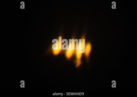 Abstract background with out of focus warm candle flames on dark night Stock Photo