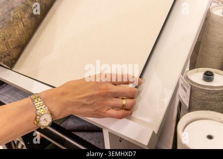 Customer Browsing Wallpaper Catalog Book in Modern Interior Design Showroom Stock Photo