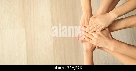 Stacked hands of diverse people in team huddle symbolizing teamwork, unity, support, collaboration and partnership with copy space Stock Photo