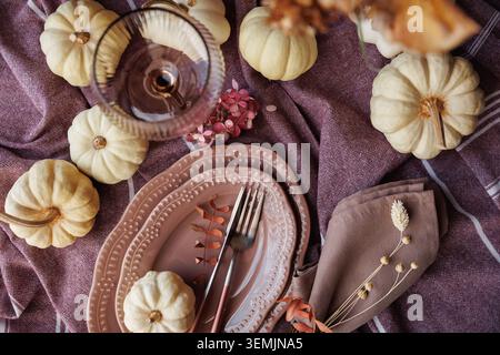 Thanksgiving table setting with rustic pumpkins and elegant tableware Stock Photo