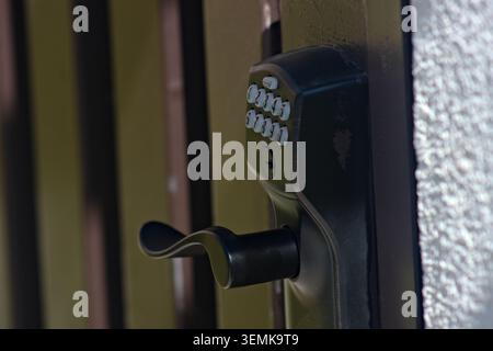 Close-up of residential keypad entry lock installed on exterior doorway in Corona, California representing modern home access control and neighborhood Stock Photo