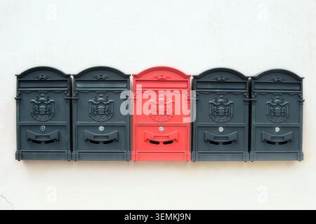 Old-fashioned black and red mailboxes on the wall Stock Photo