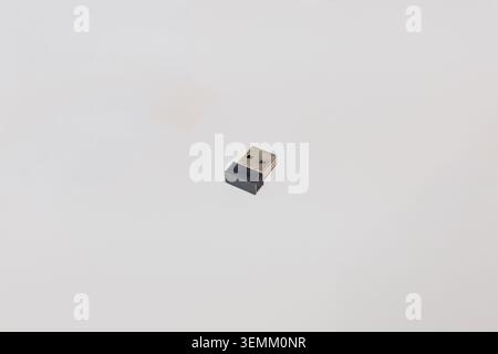 Small black and silver USB wireless dongle receiver for computer mouse on white background Stock Photo