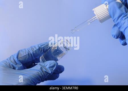 Prepare a solution using a pipette and a vial in a laboratory environment, focusing on precision and safety Stock Photo