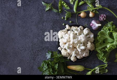 Cauliflower with vegetables and spices on a dark wooden background Stock Photo
