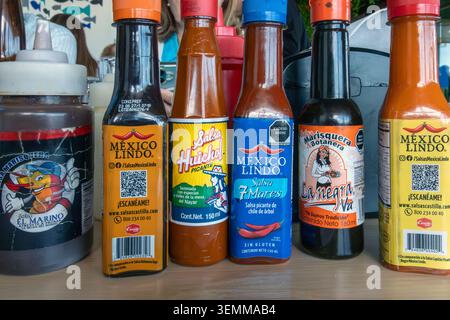 Mexican Hot Sauce Bottles and Condiments on Restaurant Table in Mexico Stock Photo