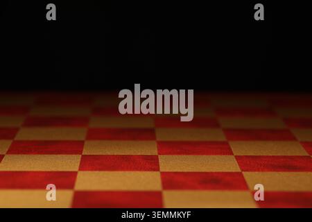 Checkered chessboard on dark background, closeup view Stock Photo