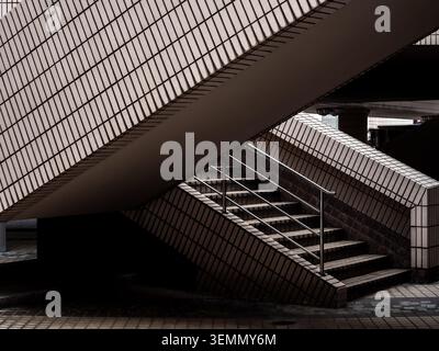 Abstract architectural composition featuring geometric staircases and tiled surfaces in modern building structure, the Hong Kong Cultural Centre. Urba Stock Photo