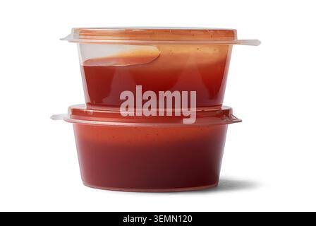 two clear plastic red tomato sauce containers isolated white background, disposable small takeaway portion cups serve along with pizzas Stock Photo