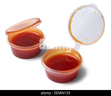 small plastic red tomato sauce containers isolated white background, clear disposable portion cup served along with pizzas, takeaway condiment Stock Photo