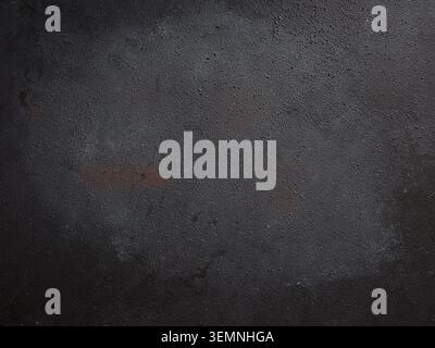 Rough black wall or desktop with textured surface creating a moody and industrial backdrop or food photography table for copy space Stock Photo