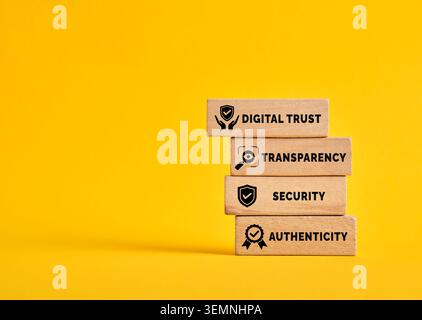 Wooden blocks displaying digital trust, transparency, security, and authenticity concepts on a vibrant yellow background Stock Photo
