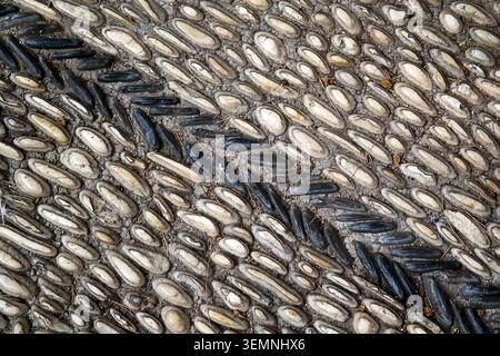 Patterned pavement in the park. Traditional pebble mosaic sidewalk Stock Photo