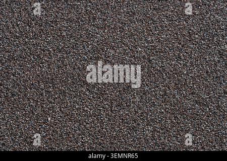 Fine grit sandpaper texture macro background abrasive sheet. Close up full frame view of dark abrasive sandpaper texture used for wood and metal finis Stock Photo