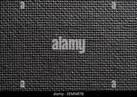 Black yoga mat texture background close up. Full frame macro view of a black rubber fitness mat texture with non slip textured grid pattern Stock Photo
