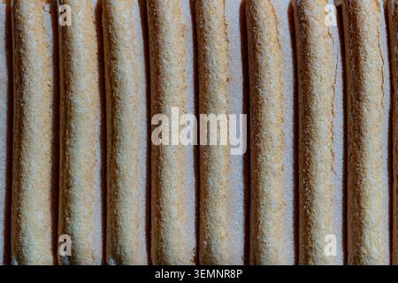 Ladyfinger biscuits row macro texture ladyfingers background. Close up full frame view of sweet spongy ladyfingers biscuits covered with sugar crystal Stock Photo